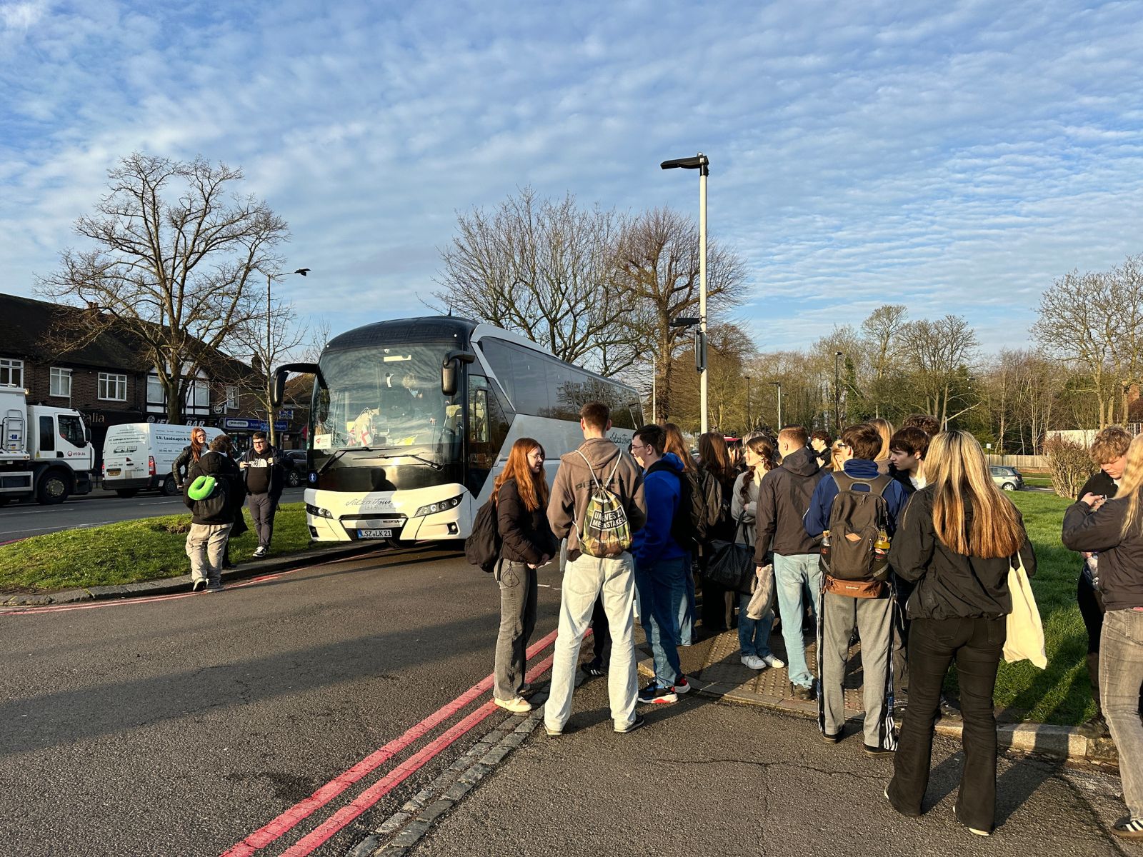 A student group waiting beside their coach at the Shirley meeting point