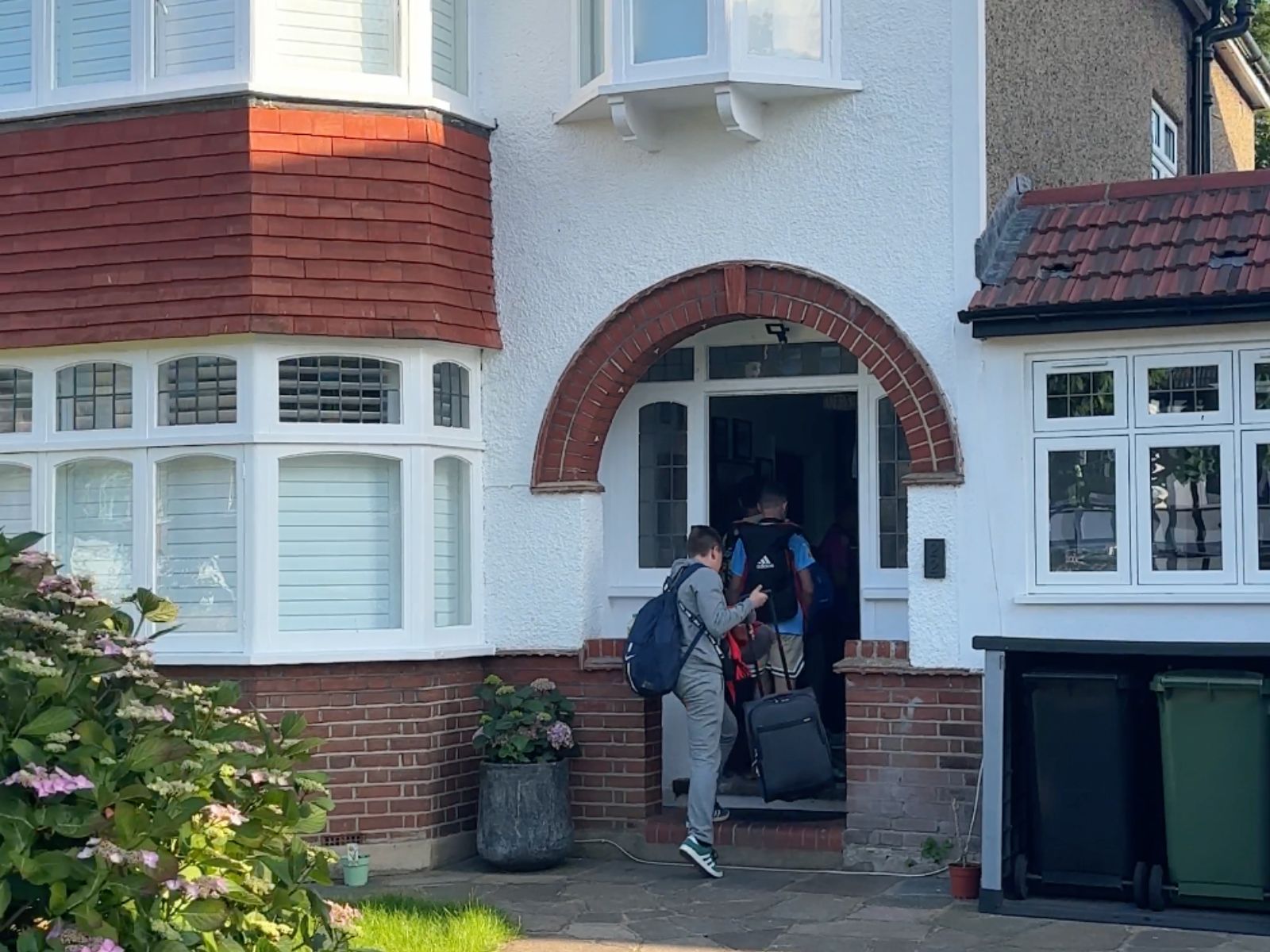 Students arriving with their luggage at the front door of a West Wickham host home